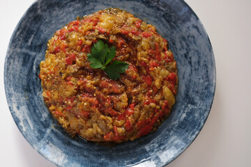 Eggplant and capia pepper mix appetizer on a white plate. Turkish food.