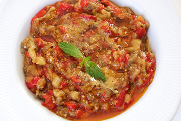Eggplant and capia pepper mix appetizer on a white plate. Turkish food. Close up