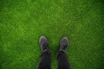 Close up photo of man foot on green grass on stadium