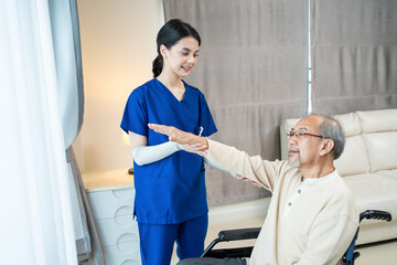 Obraz premium Asian female nurse providing physiotherapy service to senior patient.