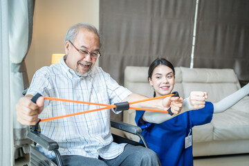 Asian therapist teaching old man to exercise by using resistance band.