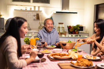 Obraz na płótnie Canvas Asian big family enjoy eating food on dining table in Christmas party.