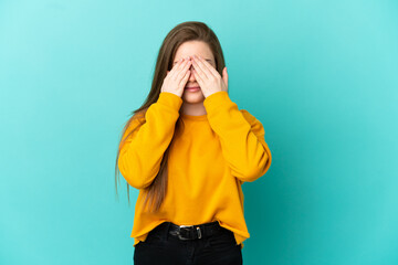 Teenager girl over isolated blue background covering eyes by hands