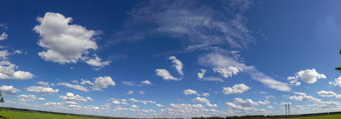 Panorama of blue sky with white fluffy clouds