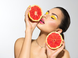 Healthy eating, diet. Beautiful healthy model girl with slices of red grapefruit, food, cosmetics concept. Beauty young fashion woman takes grapefruits, organic vegetables. Vegetarian