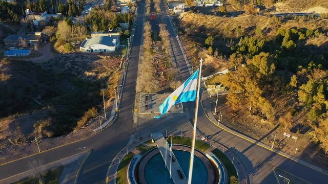 Drone films Argentine flag at the top of the mast atop the city of Neuquén, Patagonia Argentina