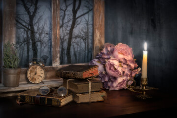 Imagen de un bodegón  en el que vemos , unos libros , reloj despertador una vela encendida , un...