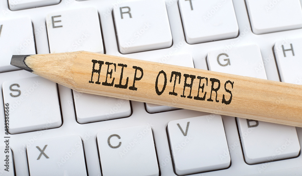 Aufkleber help others text on pencil on the keyboard background