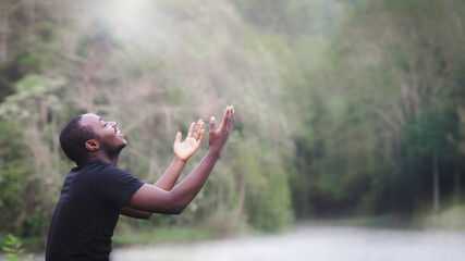 African man praying for thank god in the green nature background