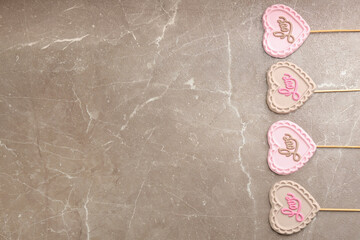 Chocolate heart shaped lollipops with word Love on light grey marble table, flat lay. Space for text