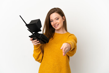 Teenager girl holding a drone remote control over isolated white background shaking hands for closing a good deal