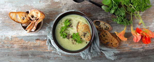 Fototapeta na wymiar flat lay bowl of broccoli cream soup with croutons and cheese on wooden table