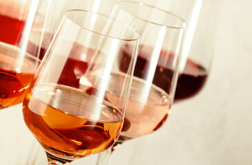 Rose wine glasses set on wine tasting. Different varieties, colors and shades of pink wines on white background