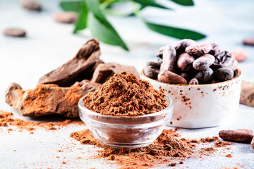 Organic cocoa powder, beans, grated lump on gray background. Copy space