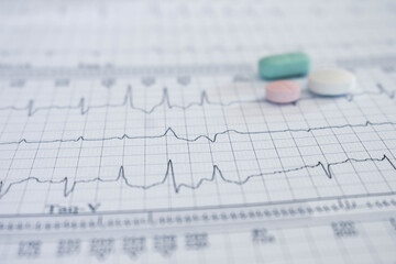 Cardiovascular disease concept. Selective focus. Colored pills on electrocardiograms with ventricular tachycardia. Life-threatening arrhythmia.