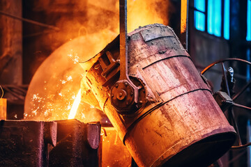 Molten metal pour from ladle Into sand mold. Iron casting process in metallurgy foundry plant,...