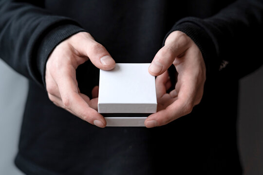 male hands holding a white box