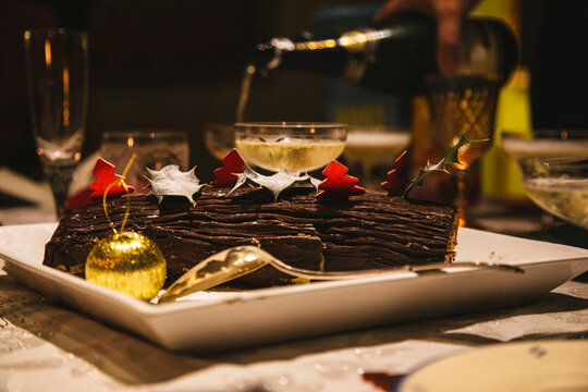 Bûche de Noël Christmas yule log cake and glass of white wine 