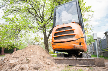 Mini excavator in orange color. construction equipment rental
