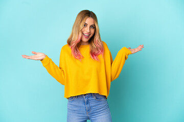 Young woman over isolated blue background with shocked facial expression