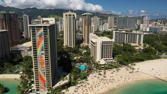 Cinematic 4K aerial drone video of high-rise hotels on the shore of Waikiki, vibrant, popular tourist destination near Honolulu on Oahu island in Hawaii known for its popular surf beach