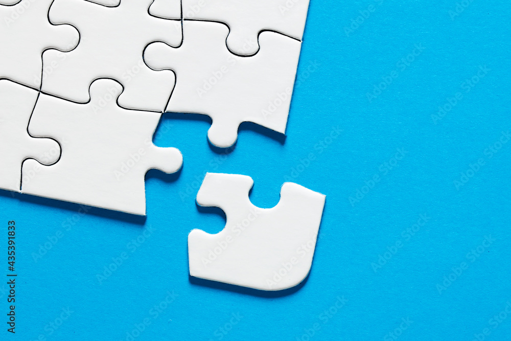 Poster one missing puzzle piece on blue background with copy space. connection or separation concept.