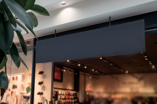 a black mockup sign over the entrance to the premium clothing store. Copy space for your text, logo, or ad.