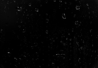 water drops on black background. abstract dew water droplets on a window glass for photo overlay...