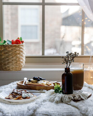 Pancakes with peaches, blueberries and banana in a cozy setting 
