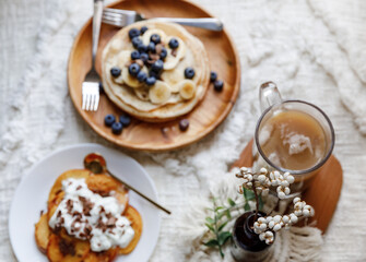 Pancakes with peaches, blueberries and banana in a cozy setting 