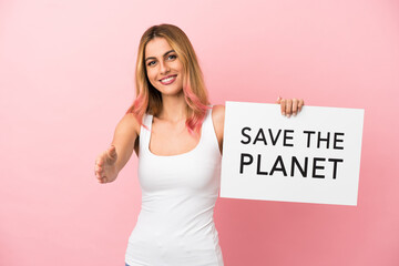 Young woman over isolated pink background holding a placard with text Save the Planet making a deal