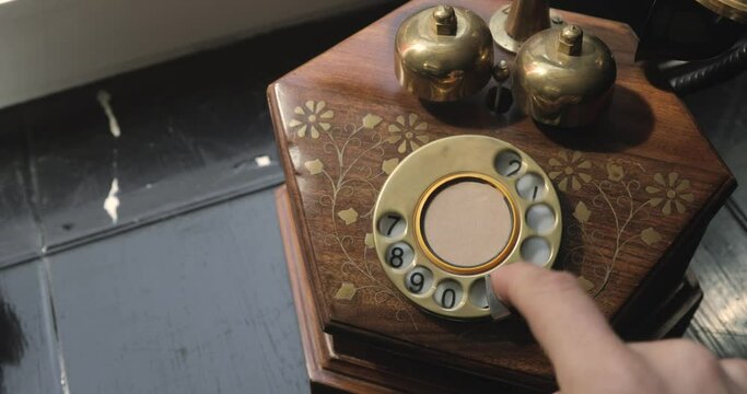 Close-up view on an old style telephone dial. Top View Of Man Dialing A Phone Number On A Vintage Retro Black Rotary Telephone