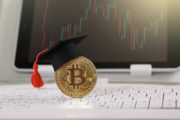 Crypto and Blockchain Education. Graduation cap on Bitcoin Cryptocurrency on keyboard. Education...