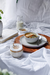 Dalgona coffee with apple oatmeal breakfast on white cozy bed