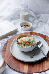 Dalgona coffee with apple oatmeal breakfast on white cozy bed