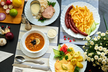 top view of different dishes and other ingredients on wooden table
