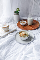 Dalgona coffee with apple oatmeal breakfast on white cozy bed