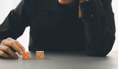 closeup woman hand choosing cross mark cube box