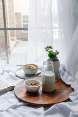 Dalgona coffee with apple oatmeal breakfast on white cozy bed