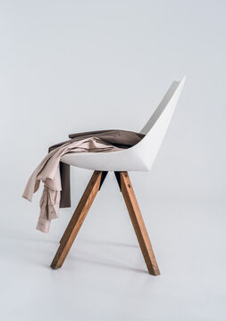 Clothes on a wooden armchair against the background of a bright room