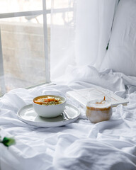 Dalgona coffee with apple oatmeal breakfast on white cozy bed