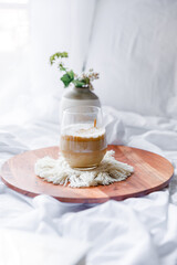 Dalgona coffee with apple oatmeal breakfast on white cozy bed