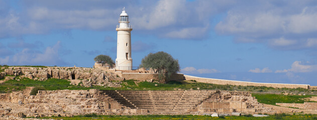 The famous archeological site in Paphos, Amphitheater with lighthouse in the background. Blue sky with clouds. - obrazy, fototapety, plakaty