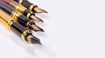 Fountain pen, four beautiful fountain pens in detail on white background, selective focus.