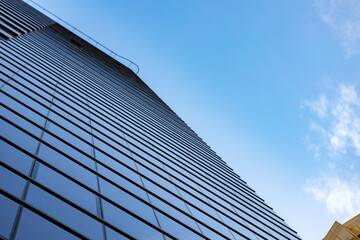 Fototapeta na wymiar Glass skyscraper against blue sky, view from bottom