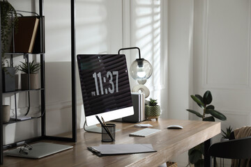 Modern computer and laptop on wooden desk in room. Interior design