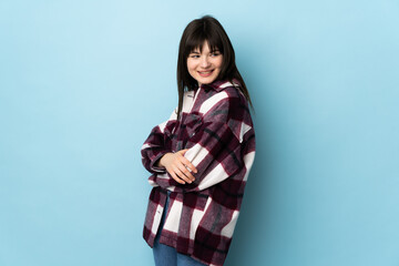 Teenager Ukrainian girl isolated on blue background looking to the side and smiling