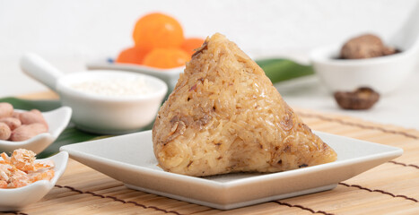 Zongzi. Rice dumpling for Dragon Boat Festival on bright wooden table background with ingredient.