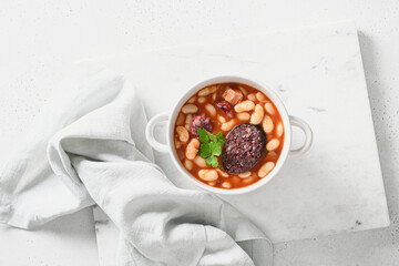 Spanish traditional fabada with haricot, bacon or streaky bacon, asturian black pudding on a white background, top view. Asturiana cuisine
