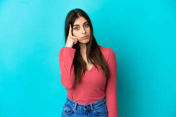 Young caucasian woman isolated on blue background thinking an idea